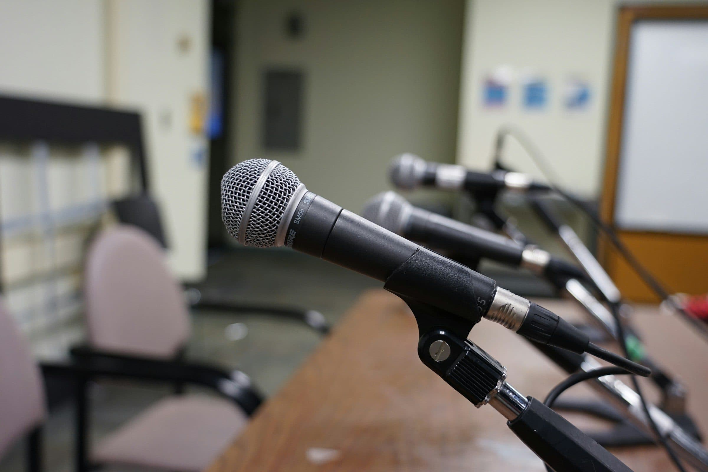 Microphones set on a desk in an empty briefing room